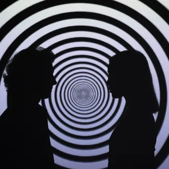 Two silhouettes of people face each other, with a hypnotic pattern of concentric circles in the background.